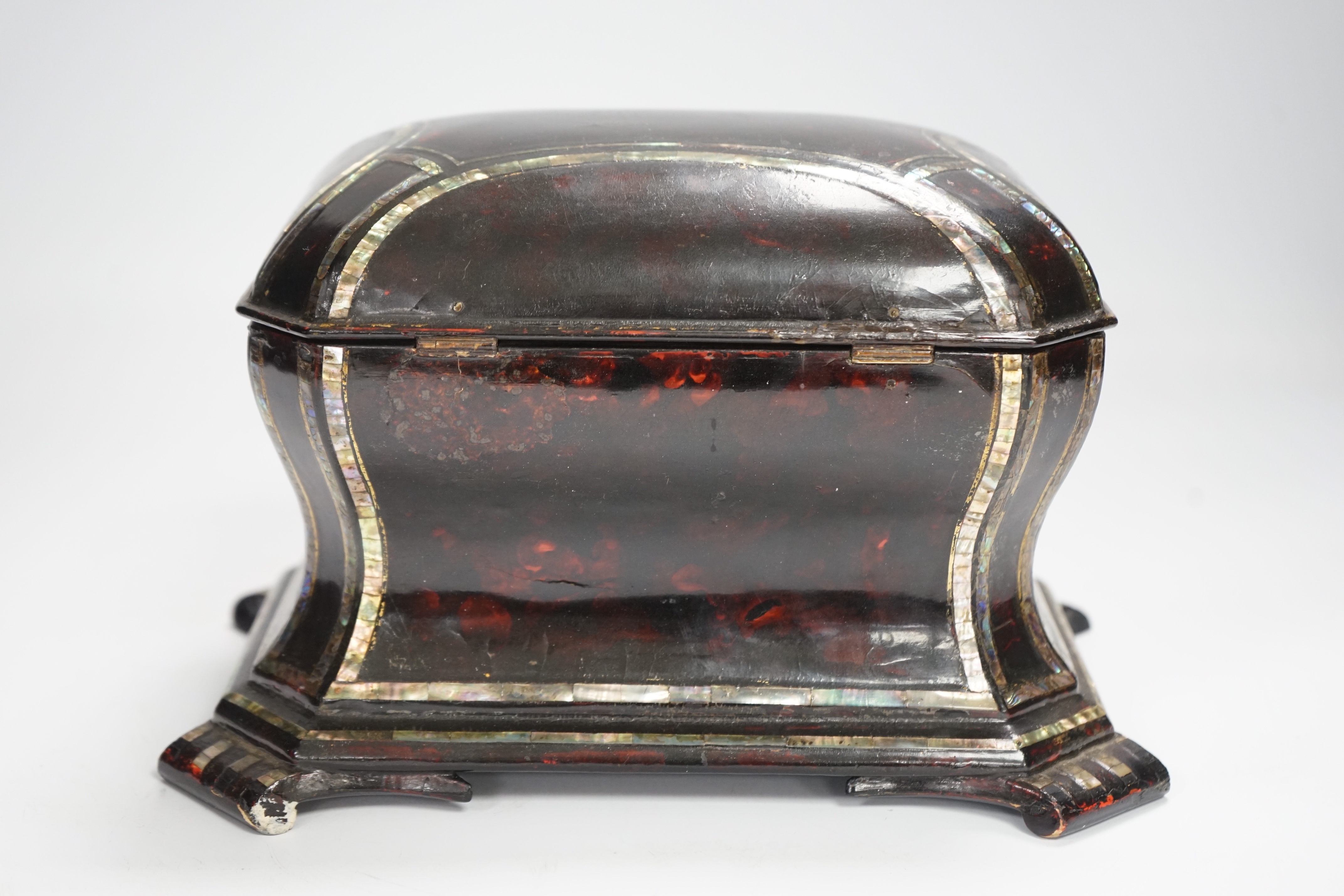 A Victorian papier mache tea caddy, stamped Jennens and Bettridge, in the form of a sarcophagus with inset mother of pearl banding, with two internal lidded compartments, 15cm high